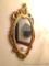 Oval Mirror: Decorative wood-frame gold-colored oval mirror. 16