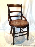 Caned Parlor Chair: Antique mahogany wood, hand-caned chair with turned front spindles. Caning in