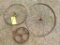 Three antique steel wheels, largest is 2 ft.