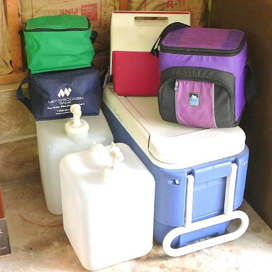 Two 5 gallon jugs with spigots; Igloo cooler with wheels and handle. Approx. 24" x 13" x 16"; more.