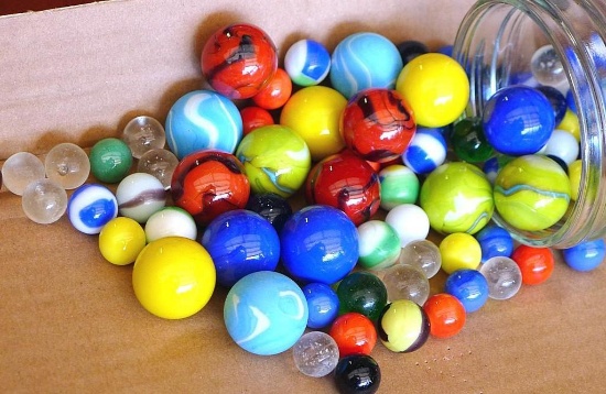 Quart jar of assorted glass marbles.