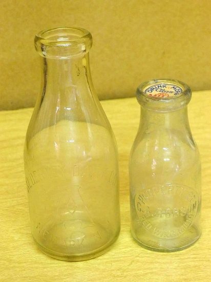 Two vintage milk jugs. 9-1/2" jug is marked Alderney Dairy Co, Newark, NJ and in good condition. 7"