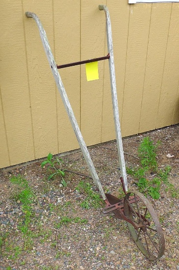 Vintage cultivator with metal wheel. Approx. 70" long, wheel is 15". In good condition.