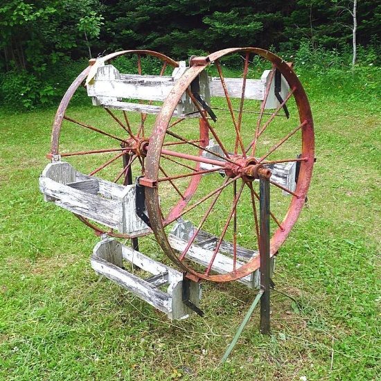 Steel wheel flower planter decoration. Approx. 43" w x 50" d x 61"h. Has six flower boxes that need