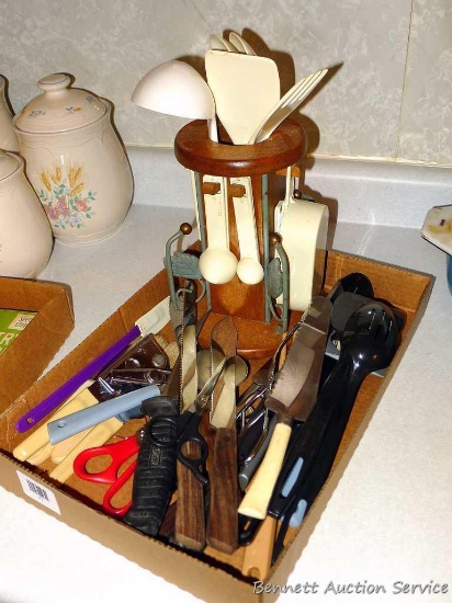 Assorted kitchen utensils including a caddy. Can opener, serving pieces, measure cups, tongs,