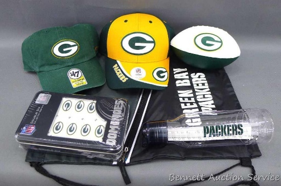 2 Green Bay Packers caps; foam football is 7" long; water bottle; dominoes; and bag. Donated by the
