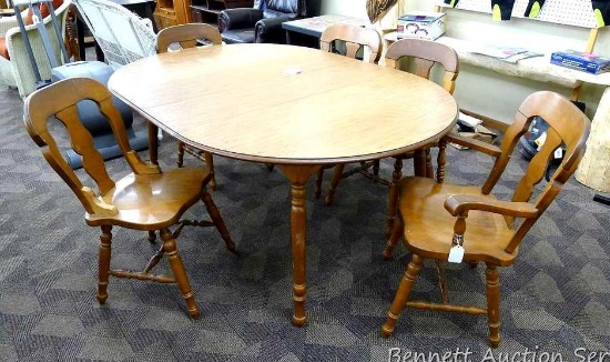 Wooden dining room table has a laminate top, 2 leaves, 2 captains chairs and 2 regular chairs. One