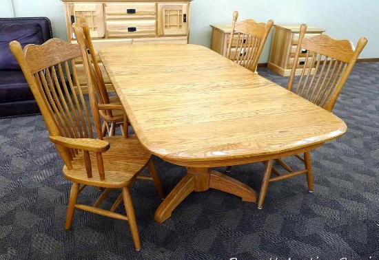 Beautiful oak dining room table with 2 captains, 2 regular chairs and 2 leaves. Appears in very