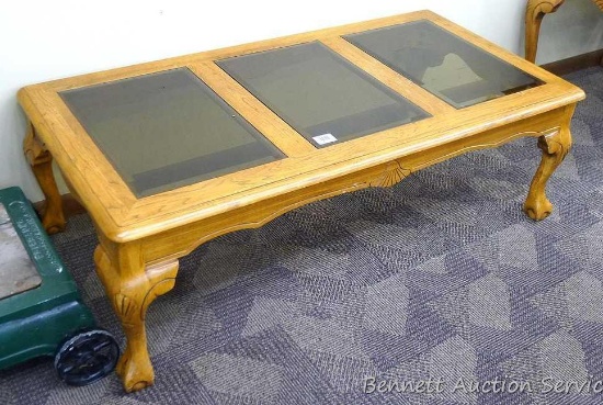 Wooden coffee table with 3 smoked colored glass panels for the table top; very sturdy; has a few