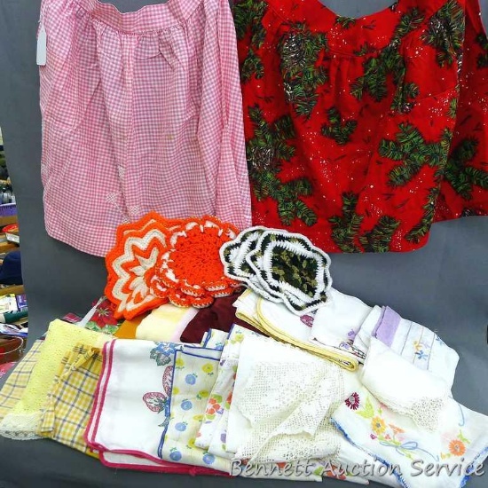 Assorted vintage kitchen linens including holiday tablecloths, napkins, gingham & Christmas aprons,