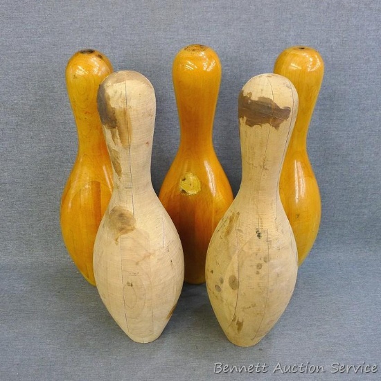 Three varnished wooden bowling pins and two unfinished wooden bowling pins, 15" tall.