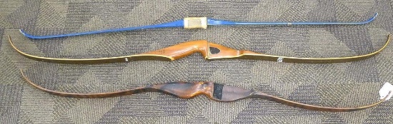 Three recurved bows, two are wooden and one is fiberglass. One wooden bow is a Talo by American,
