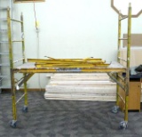 Perry rolling scaffold. Adjustable height platform is approx 6' x 2-1/2'. Side frames are 6-1/2'