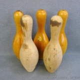 Three varnished wooden bowling pins and two unfinished wooden bowling pins, 15