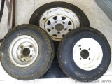 Assortment of trailer tires. Includes 4.80 - 12 tire, appears new and mounted on a five hole rim.