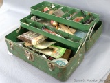 Vintage metal fishing tackle box with two trays and includes assorted lures, bobbers, string, baits