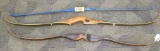 Three recurved bows, two are wooden and one is fiberglass. One wooden bow is a Talo by American,