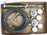 Oxygen and acetylene torch set includes Uniweld gauges, torch head, hose, and brazing head and tips.