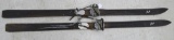 Pair of vintage CTC wooden downhill skis includes metal and leather bindings. Have been used as