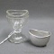 Footed glass eye cup, plus a little aluminum eye cup. Both are in good shape.