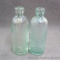 Two antique green glass bottles from 'Ashland Bottling Works, Ashland, Wis.'. Each bottle is 7-1/4