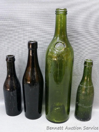 Tall green glass bottle with an interesting design stamped seal at base of bottle neck, measures 3"