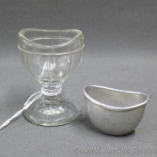 Footed glass eye cup, plus a little aluminum eye cup. Both are in good shape.