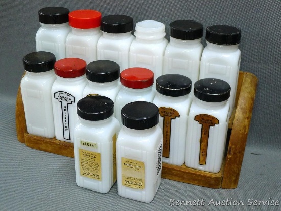 Vintage wooden spice rack with fourteen spice bottles. Each bottle is 4-1/4" and in good condition.