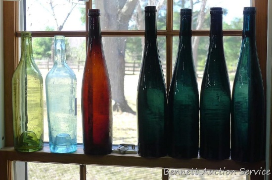 Nice collection of seven pretty wine bottles, up to 14" tall. Bubbles noted in glass of the light