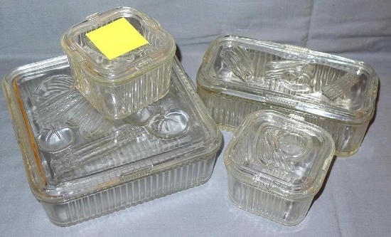 Four piece set of glass vegetable pattern refrigerator dishes with lids. Set includes an 8" x 8"