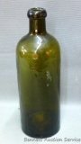 Antique green brown cast glass bitters bottle has an applied lip. Bottom is embossed 'Hunyadi Janos
