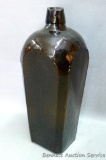 Brown green bitters bottle with circle and five dots pattern on the bottom. Dump dug bottle has a