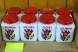 Wonderful set of eight little spice jars. Each has a cheery red and yellow floral design on its