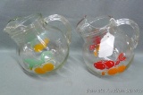 Two retro fruit themed ball style pitchers are in overall good condition with one chip noted on rim