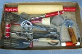 Retro red handled kitchen utensils including rolling pin, egg beaters, strainer, masher, pastry