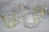 Four vintage glass serving pitchers. Tallest is a little more elegant than the others and stands