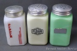 Three large shakers of varying colors. Includes a jade green flour shaker, a creamy white flour