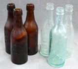 Three brown and three green glass bottles all from 'Ashland Bottling Works, Ashland, Wis.'. Tallest