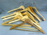 Ten sturdy wooden clothes hangers including one from J. Kadetski Custom Garment Makers of East