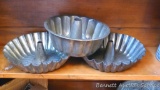 Matched pair plus one other style of tube pan. All are in good condition. Matched pans are each