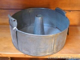 Antique tube pan with vents / feet for cooling. Measures 8-1/2