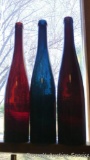 Blue-green, brown and orange-brown glass wine bottles with divots in bottoms. All are 14