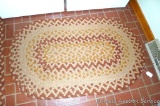 Braided area rug in neutral colors matches lot 542. This rug measures 54