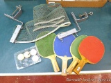 Ping pong table folds for easy storage. Some trim is loose. Comes with net, paddles, and a few