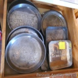 Nine baking pans including Py-O-My pie pans, cake pans, baking sheets. All are in overall good