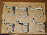 Six matching cast iron coat hooks, 3