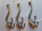 A trio of remarkable cast iron triple hooks are each 6-1/2