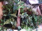 Two boxes full of faux greenery including ferns, ivy, more.