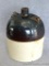 Two toned one gallon stoneware bottle or jar. Handle ears are intact, but handle is missing. White