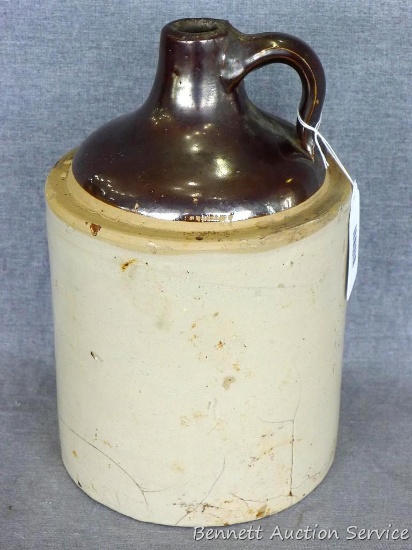 One gallon stoneware jug stands 11" tall and is in overall good condition with a few hairline cracks